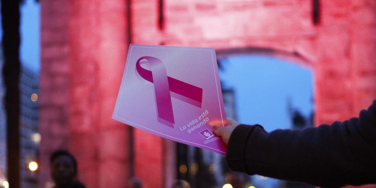 Una mujer muestra el lazo rosa de lla campaña contra el cáncer de mama. EFE/Federico Anfitti/Archivo