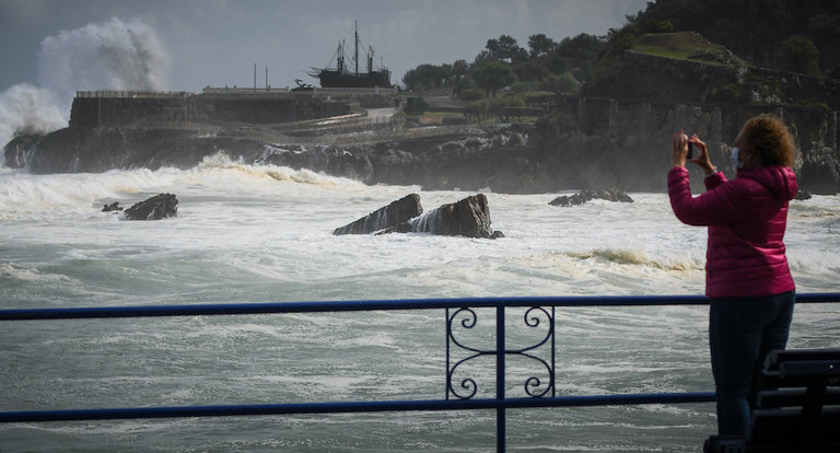 Una mujer hace una foto en paseo de la playa del Camello en Santander la pasada semana cuando azotó el temporal Álex. / Hardy / ALERTA