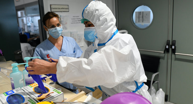 Una sanitario se prepara para entrar en la zona UCI donde permanecen los pacientes más graves infectados por el coronavirus. / HARDY