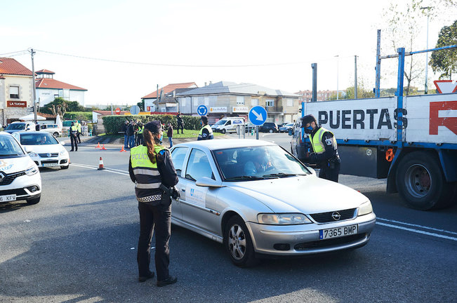 Un ciudadano con su vehículo para junto al agente en un control realizado hoy en Corbán, Santander. / ALERTA