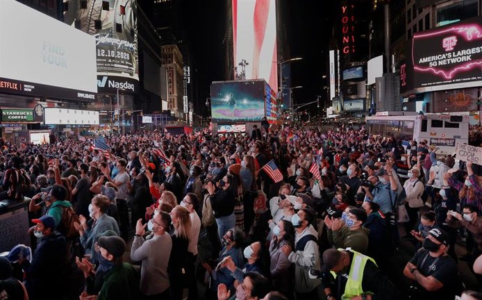 La gente se reúne para ver al presidente electo de EE. UU., Joe Biden, pronunciar un discurso después de que las principales organizaciones de noticias convocaron la elección de Biden, derrotando al actual presidente de EE. UU., Donald J. Trump, en Times Square en Nueva York, EE. UU., 7 de noviembre de 2020 (Elecciones, Estados Unidos). , Nueva York) EFE / EPA / PETER FOLEY