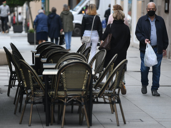 Una persona observa las mesas vacías de un establecimientos hostelero en el Paseo Pereda de Santander. / HARDY