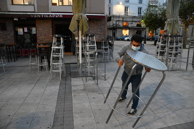 Un trabajador de la hostelería coloca las mesas para iniciar su jornada en la Plaza de Cañadío de Santnader. / HARDY