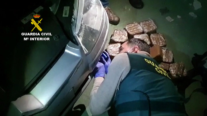 Un agente de la Guardia Civil extrae el hachis escondido en un coche. / OPC