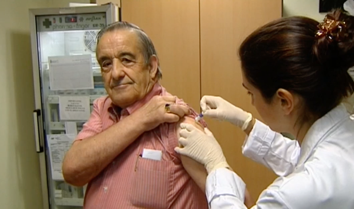 Una sanitario vacuna a un hombre de avanzada edad.