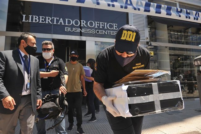 Varios policías salen con documentación de la clínica del médico de Maradona. / EFE