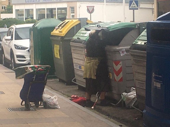 Una anciana rebusca en la basura en la calle Joaquín Cayón en el día de ayer. / S.D.