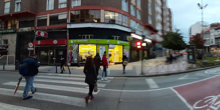 Varias personas cruzan la calle José Posada Herrera junto a unos comercios cerrados. / S.D.