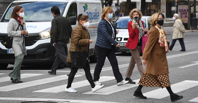 Varias personas cruzan una calle de Santander ataviadas con su mascarilla en el primer lunes tras el levantamiento de la movilidad en Cantabria. / HARDY