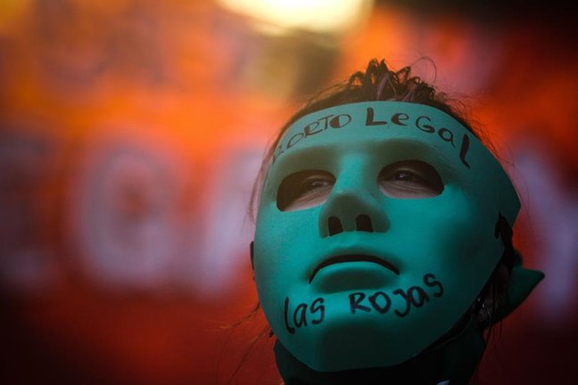 Un manifestante enmascarado pro-aborto espera durante la votación en el Senado por la legalización del aborto hoy, afuera del Congreso de la Nación, en Buenos Aires (Argentina). EFE/ Juan Ignacio Roncoroni
