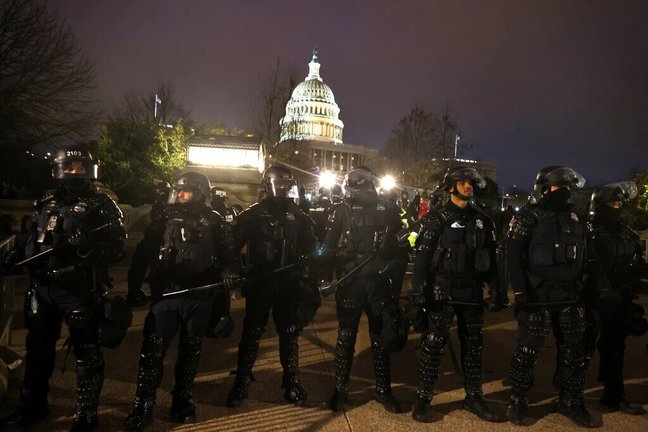 Oficiales de policía con equipo antidisturbios se alinean frente al Capitolio después de ser invadido por una turba violenta. Tasos Katopodis/Getty Images