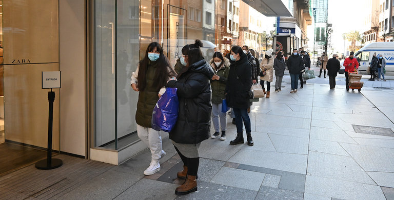 Varias personas esperan en la entrada de un comercio del centro de Santander. / Hardy
