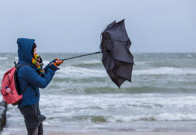 Un hombre intenta controlar su paraguas por la fuerza del viento. / ALERTA