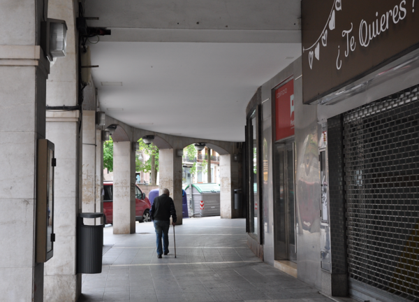 Una persona de avanzada edad pasea por los soportales en el centro de Torrelavega. / S.D.