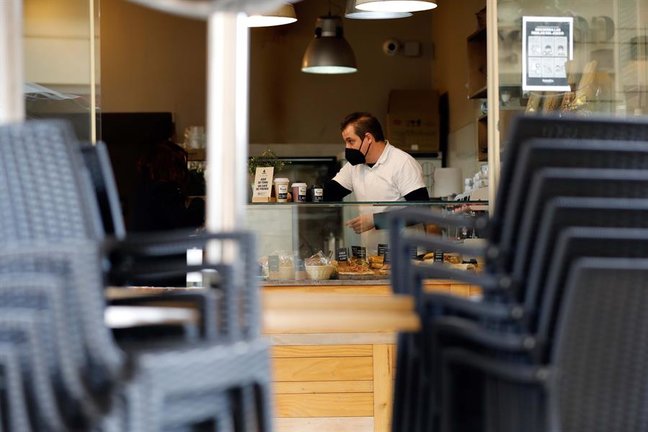 Un camarero prepara cafés para llevar (único formato permitido) el día en el que toda la hostelería comienza la primer jornada de cierre total cumplindo las nuevas restricciones aprobadas por la Generaalitat Valenciana.EFE/ Ana Escobar