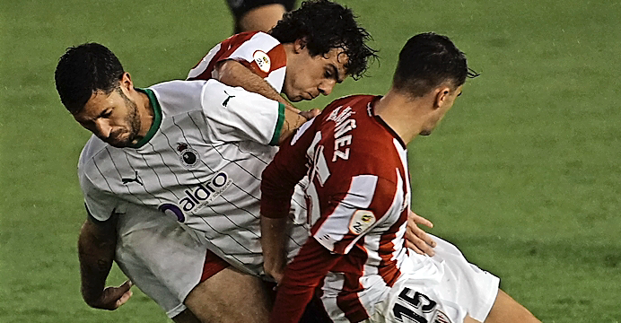 Álvaro Cejudo, ayer titular en la media punta, rodeado de dos jugadores del Bilbao Athletic. / Hardy