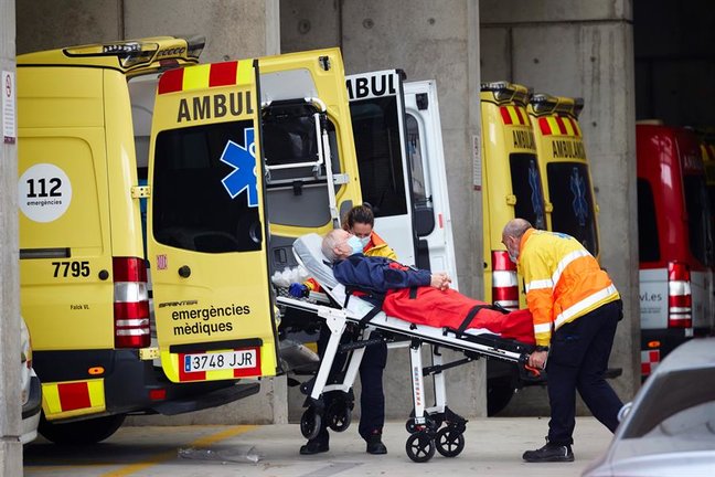 Dos técnicos de emergencias trasladan a un paciente en la zona de urgencias del Hospital Universitario de Bellvitge este lunes. EFE/Alejandro García