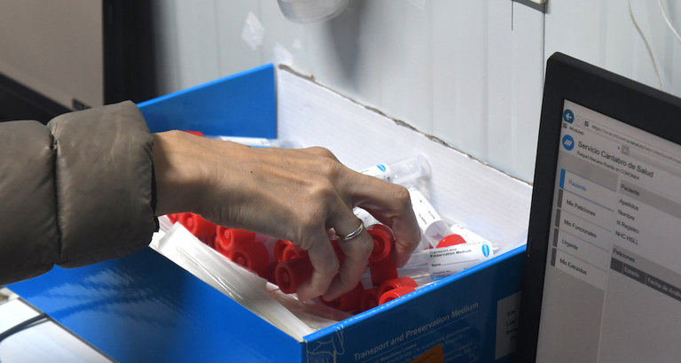 Una tecnico sanitario recoge los recipientes que utiliza para las muestras de analizar en el puerto de cribaje para la detección del virus en Santander. / HARDY