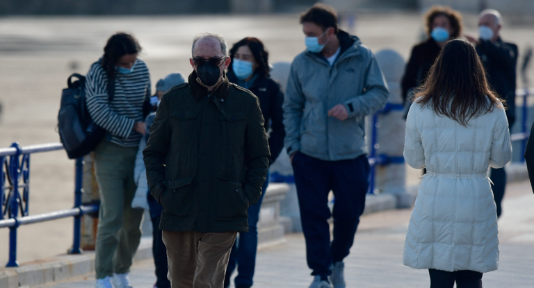 Varias personas con mascarilla pasean por las inmediaciones de la playa del Sardinero. / HARDY