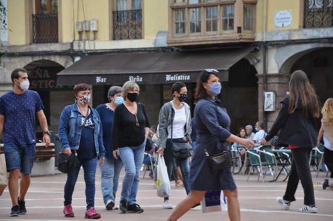 Varias personas transitan con mascarilla por la plaza roja de Torrelavega. / S.D.