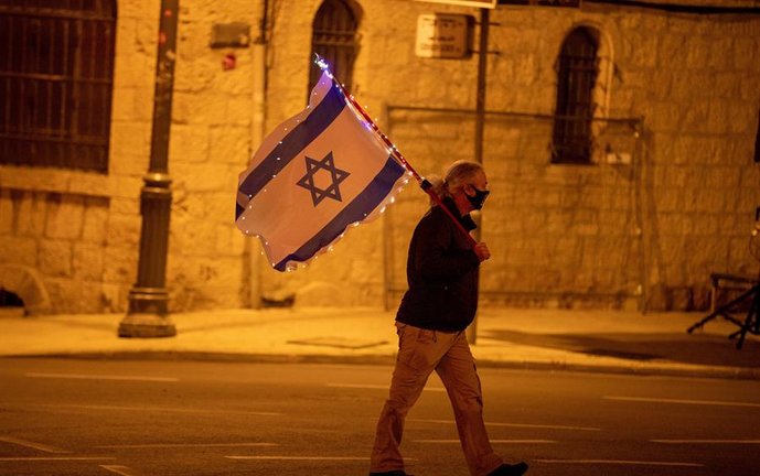 Un manifestante israelí sostiene la bandera israelí durante una protesta frente a la residencia del primer ministro israelí, en Jerusalén, Israel, el 6 de febrero de 2021. El primer ministro israelí Netanyahu se enfrenta a un juicio en curso por cargos de fraude, soborno y abuso de confianza, su juicio está programado para el 08 de febrero en el tribunal de distrito de Jerusalén. (Protestas, Estados Unidos, Jerusalén) EFE/EPA/ATEF SAFADI