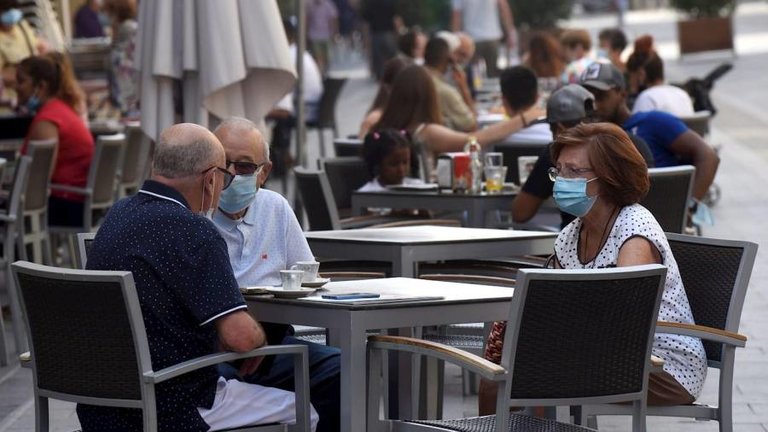 Foto de archivo de varias personas con mascarilla en la terraza de un bar. EFE