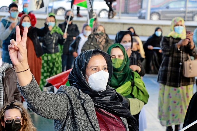 Una mujer con mascarilla levanta la mano con el signo de la paz en la manifestación por el Sáhara libre en Torrelavega. / J. PALAZUELOS