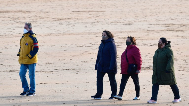 Varias personas con mascarilla caminan por la playa del Sardinero en una foto de archivo. / Hardy