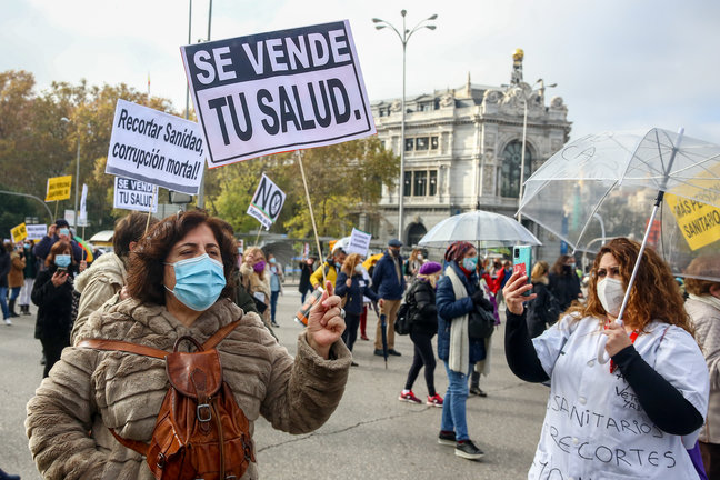 Archivo - Una mujer sostiene una pancarta donde se lee "Se vende tu salud" durante una manifestación de la Marea Blanca en Madrid en noviembre de 2020. 