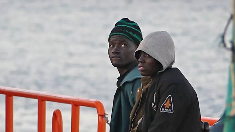 Dos jóvenes migrantes bajan de un barco de la Cruz Roja en el puerto de Arguineguín, en Mogán (Gran Canaria, España) 