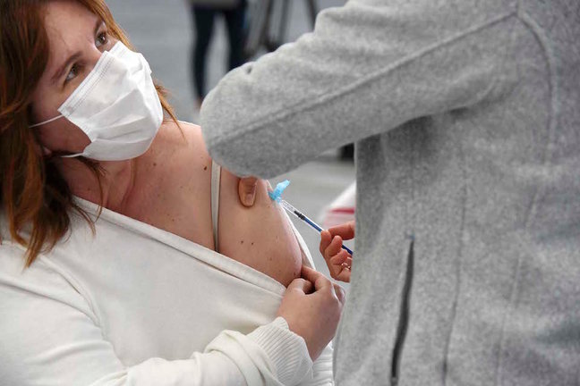 Un sanitario vacuna a una mujer en el Instituto Ferial de Vigo, en Pontevedra, Galicia. / E. PRESS