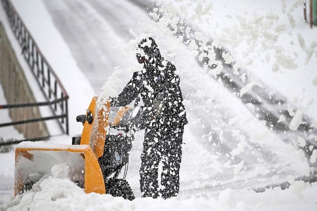 Una persona ayer durante las labores de retirada de nieve en una carretera en Brañavieja. /Pedro Puente Hoyos