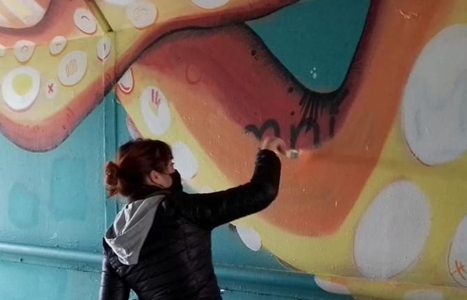 Marina Casao restaurando uno de sus murales.