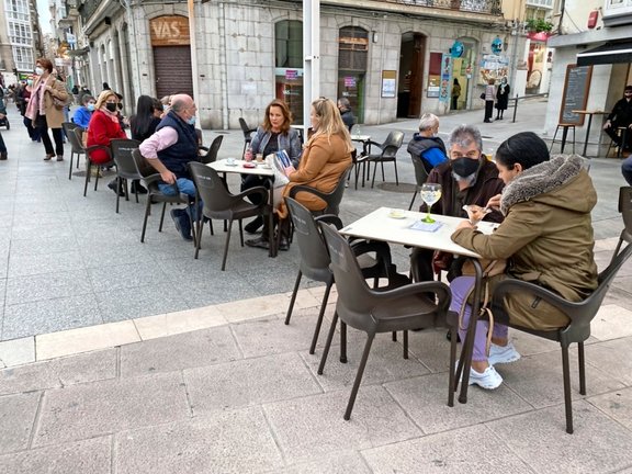 Varias personas sentadas en una terraza ampliada en el centro de Santander. / HARDY