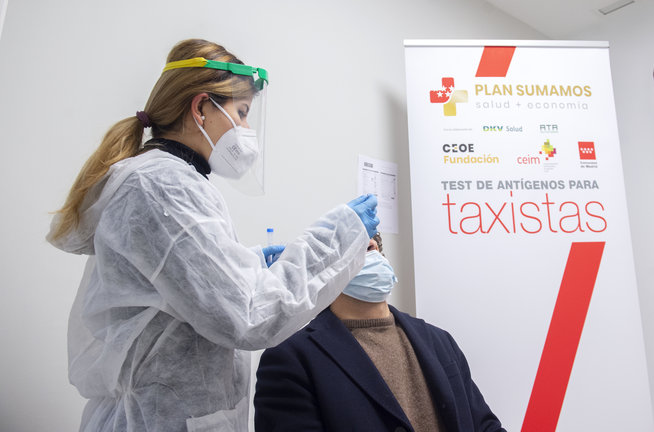 Una trabajadora sanitaria realiza un test de antígenos a un taxista de la Comunidad de Madrid, en Madrid.