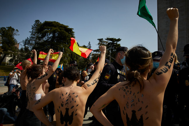 Varias activistas de Femen con águilas franquistas dibujadas en la espalda durante un acto por el Día de la Victoria en el LXXXII Aniversario de la “Liberación de Madrid”, en el Arco de la Victoria, en Madrid (España), a 28 de marzo de 2021.El colectivo a
