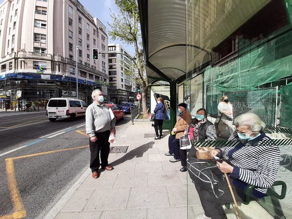 Varias personas con mascarilla esperan al autobús en el centro de Santander. / S. Díaz