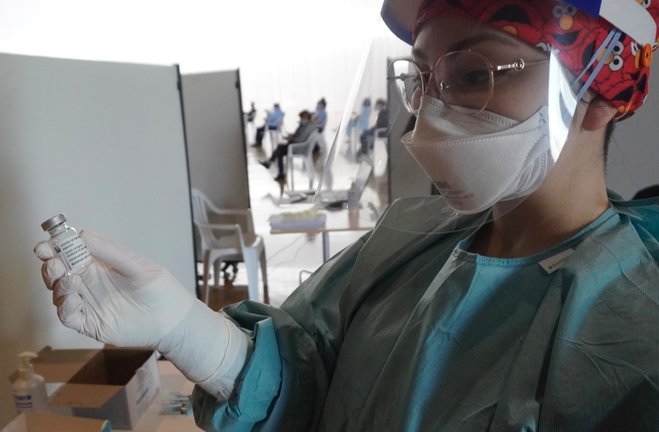 Una sanitario muestra la dosis al fotógrafo de ALERTA durante el proceso de vacunación contra el coronavirus en el Palacio de Exposiciones de Santander. / Hardy