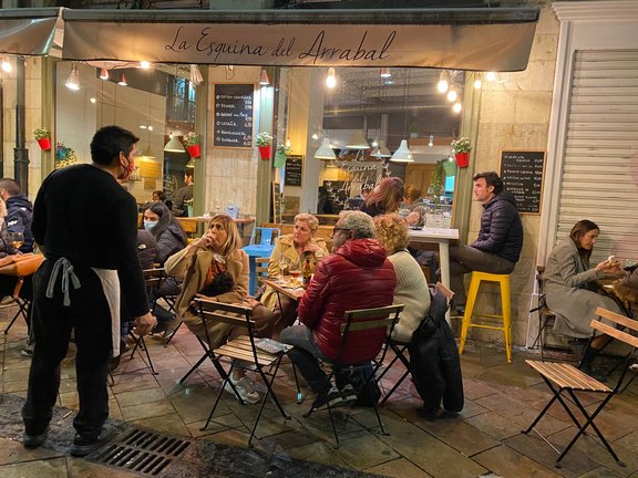 Un camarero conversa con los clientes en la terraza de un restaurante en Santander. / HARDY