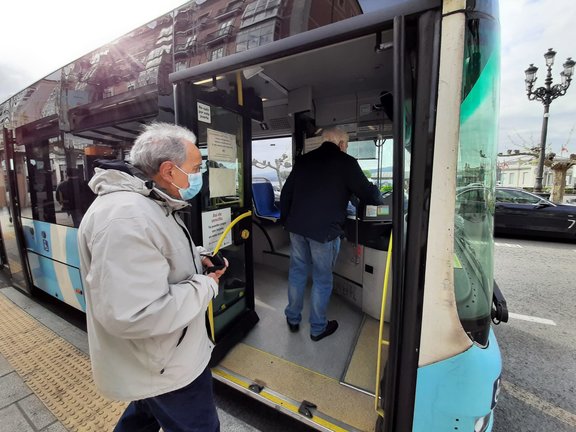 Dos personas con mascarilla suben al autobús en Santander. / S. Díaz
