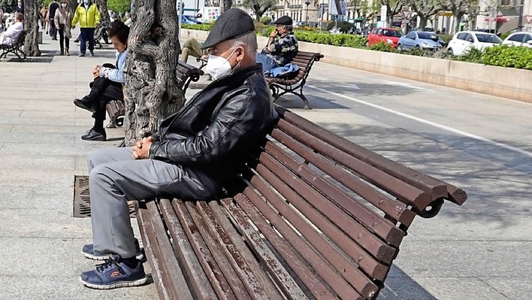 Una persona de avanzada edad sentado un bando en el Paseo Pereda de Santander. / Hardy