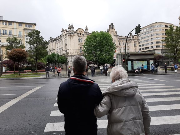 Una persona agarra a una persona de avanzada edad en el día de hoy por el centro de Santander. / S. Díaz