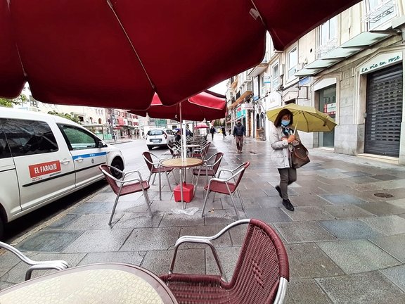 Una persona con mascarilla observa como el fotógrafo de este medio toma la instantánea en el centro de Santander. / S. 
Díaz