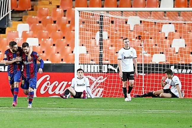 El jugador del FC Barcelona, Jordi Alba felicita a su compañero Leo Messi tras marcar el primer gol de penalti al Valencia CF. / EFE-Kai Försterling