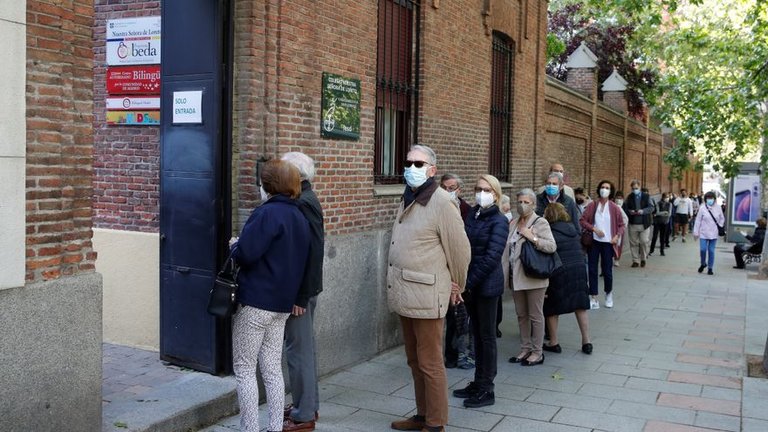 Varias personas hacen cola para ejercer su derecho al voto en el colegio electoral de Nuestra Señora de Loreto en Madrid durante la jornada electoral de este martes. EFE/ Juan Carlos Hidalgo