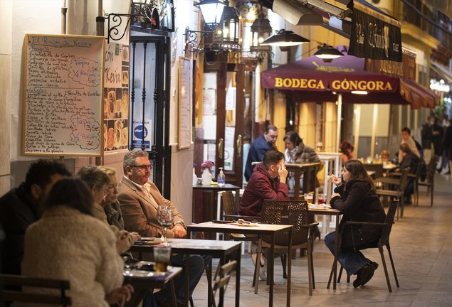 Archivo - Varias personas en la terraza de un bar, en Sevilla