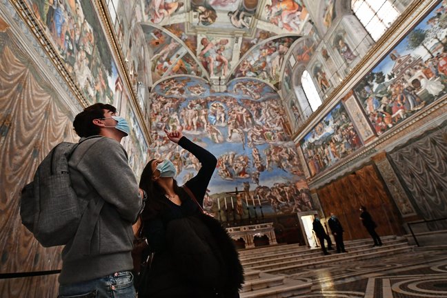 Una pareja contempla los frescos del Día del Juicio Final de la Capilla Sixtina de El Vaticano.