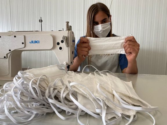 Una empleada fabrica mascarillas de tela reutilizables.