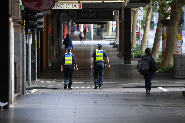 Agentes de policía caminan por la calle Swanston en Melbourne, el sábado 13 de febrero de 2021. Victoria ha entrado en un bloqueo "corto y brusco" durante cinco días ante el temor de que la cepa altamente infecciosa del Reino Unido del coronavirus se haya extendido en la comunidad. (AAP Image/Erik Anderson) SIN ARCHIVO