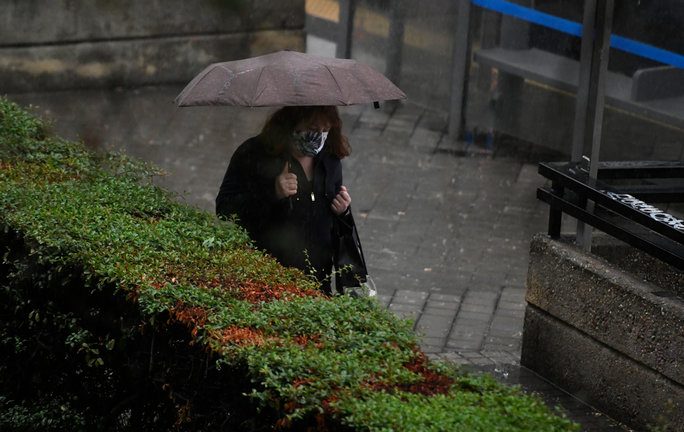 Archivo - Una persona camina bajo la lluvia protegida con un paraguas, en Madrid (España) a 24 de septiembre de 2020. La ciudad ha registrado un chubasco intenso este jueves entre las 08.30 y las 10.00 horas en el que se han acumulado entre 17 y 19 litros